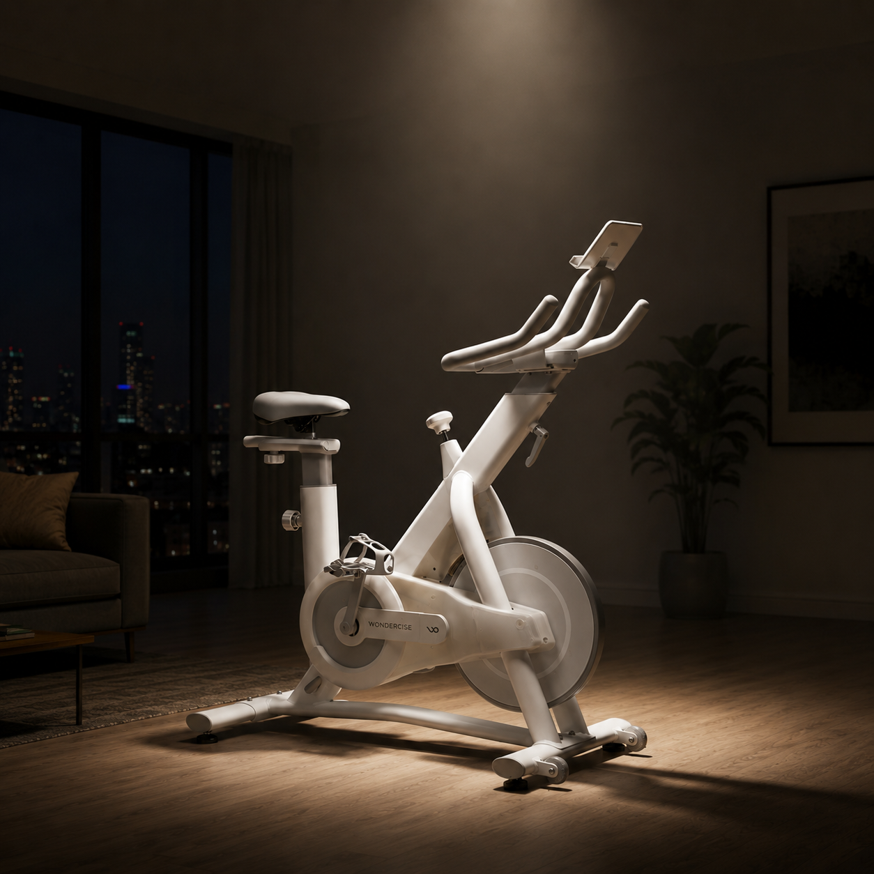 White Wonder Core indoor cycling bike with a tablet holder in a warm, dimly lit living room, illustrating the cardio and fat-loss benefits of indoor cycling