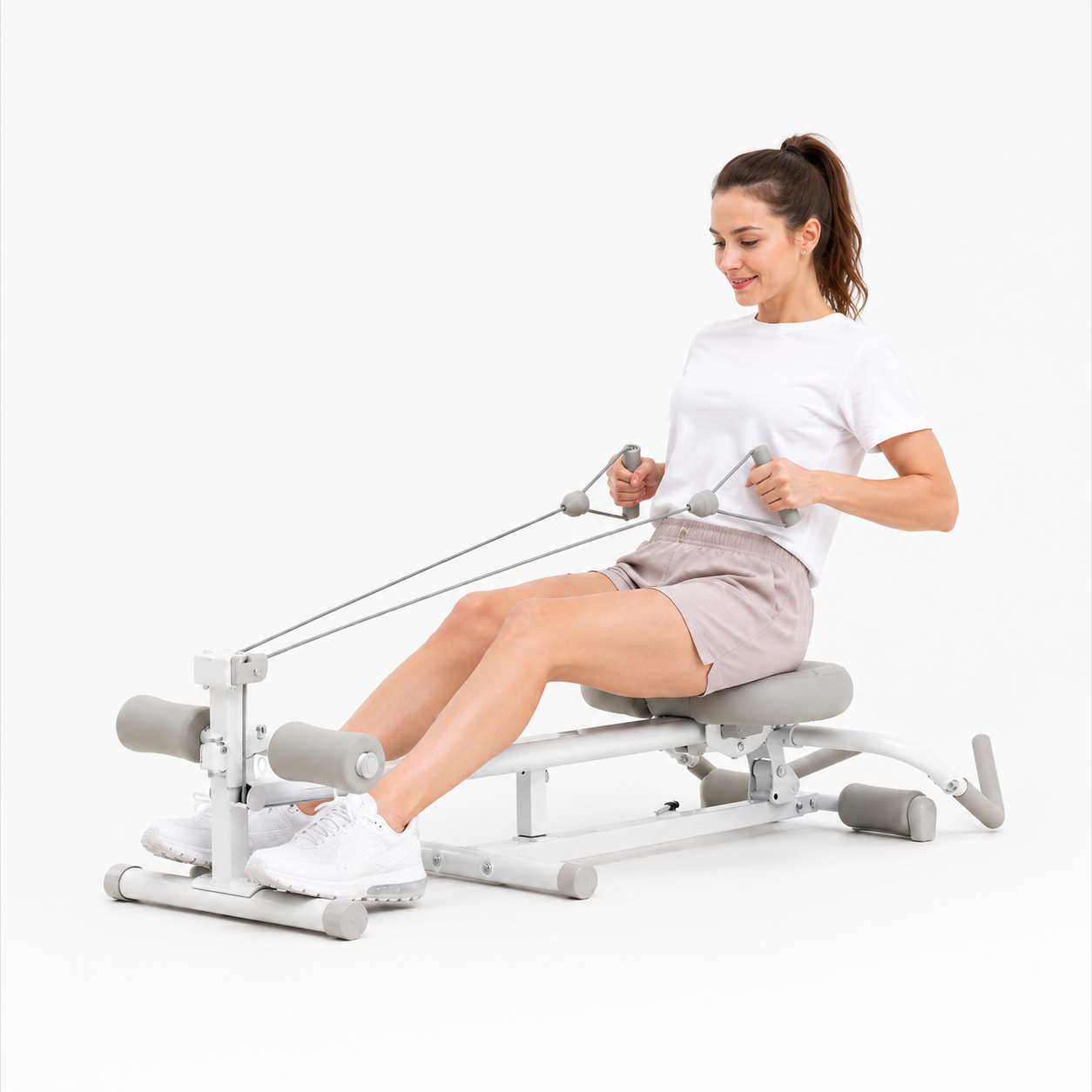 Woman using the Wonder Core Pro Max 4-in-1 machine in rowing mode on a white background, demonstrating proper rowing-machine form for beginners